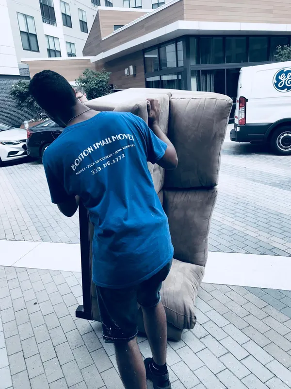 Boston Small Moves movers carrying a sofa outside an apartment building