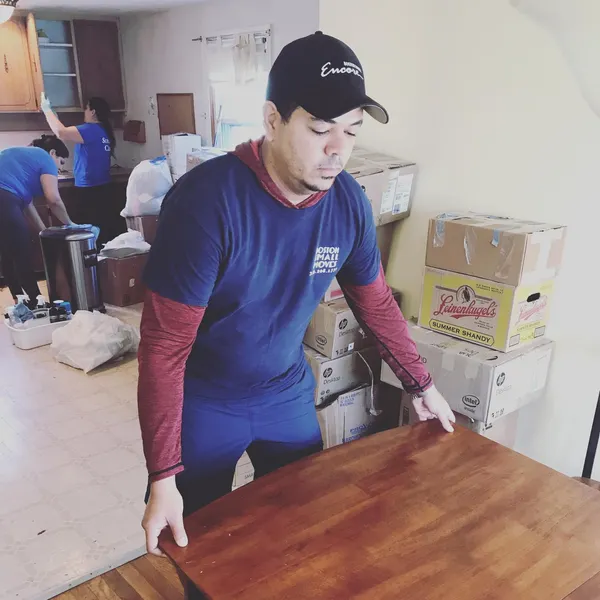 Boston Small Moves crew carrying a wooden table inside a home