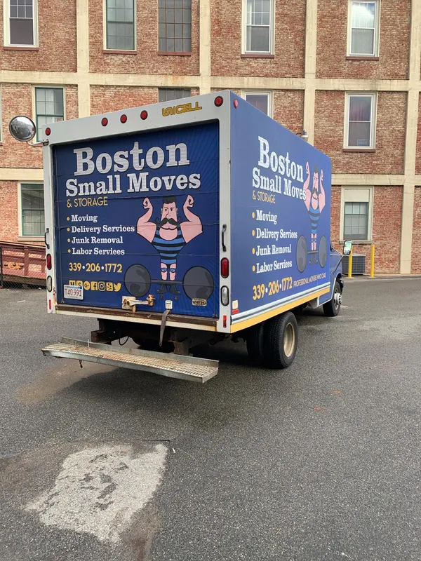 Moving truck outside a brick mill-style apartment building